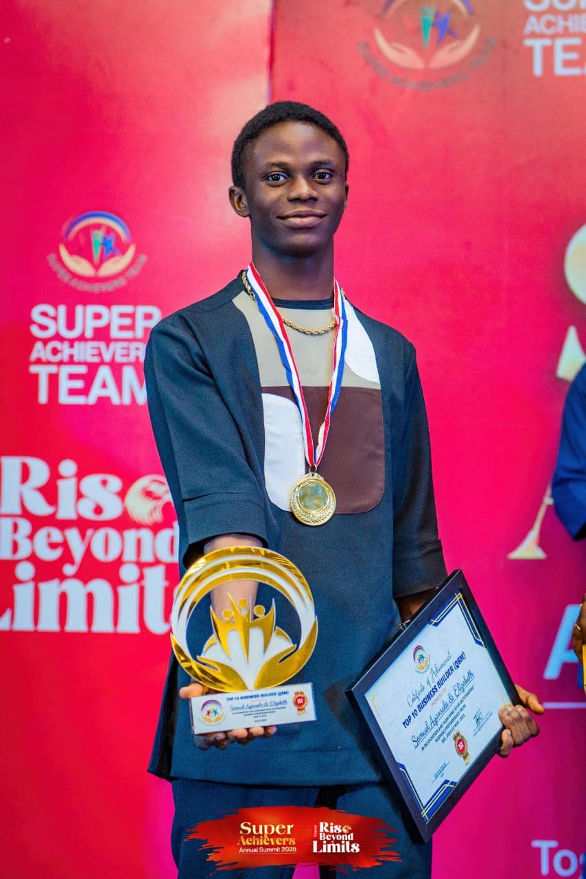 Smiling young man holding a gold trophy and certificate while wearing a medal.
