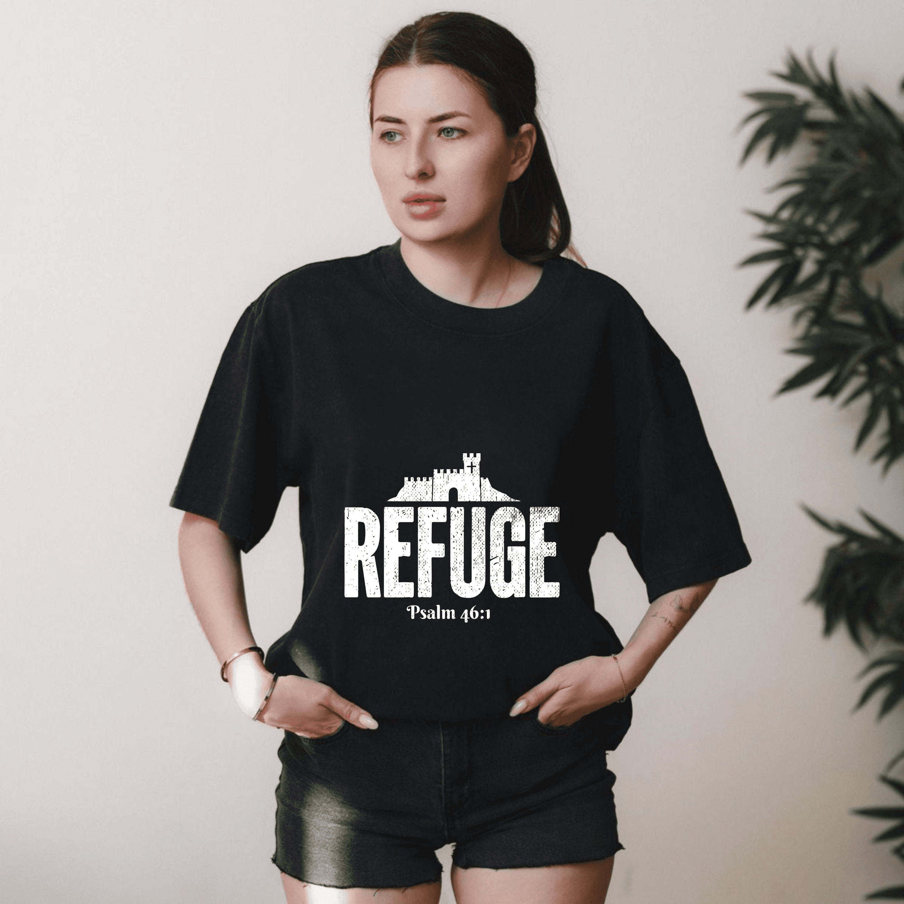 Woman wearing black t-shirt with white castle graphic, 'REFUGE' text, and Psalm 46:1.